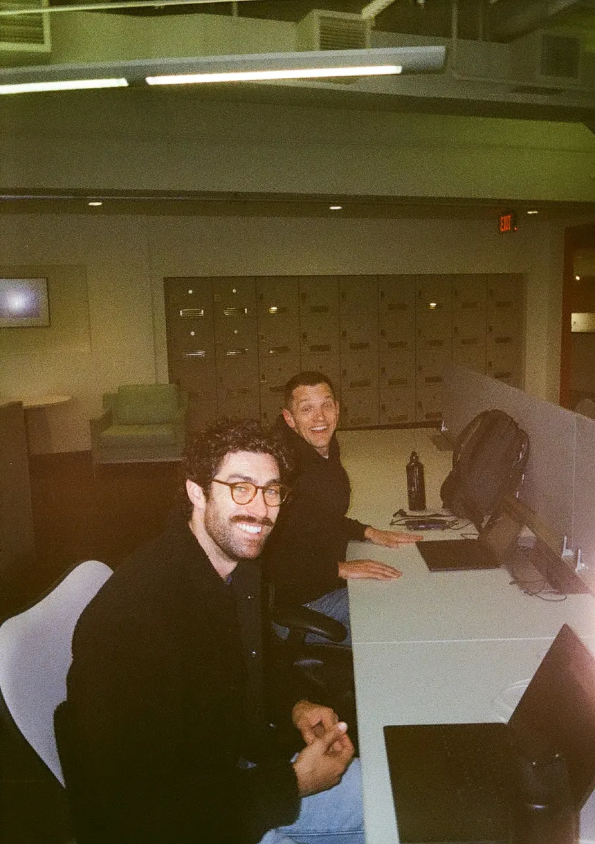 Two members of the Thread team at their desks, looking up from their laptops.