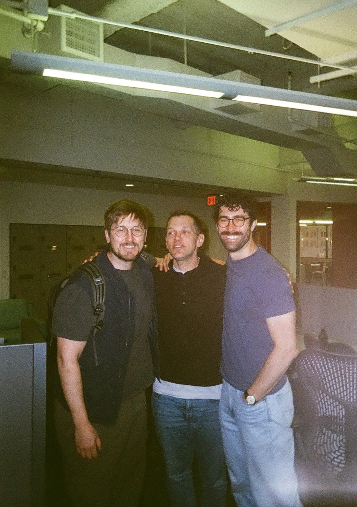 The three co-founders arm in arm in the office.