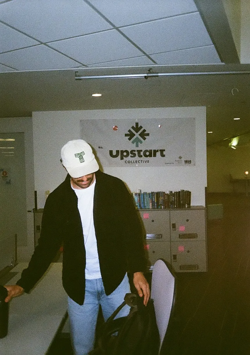 A Thread teammate in a Thread-logo cap walking through the coworking space.